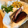 Kids BBQ meal with smoked ribs, Velvety Mac & Cheese, and garlic green beans served in a child-sized delivery tray