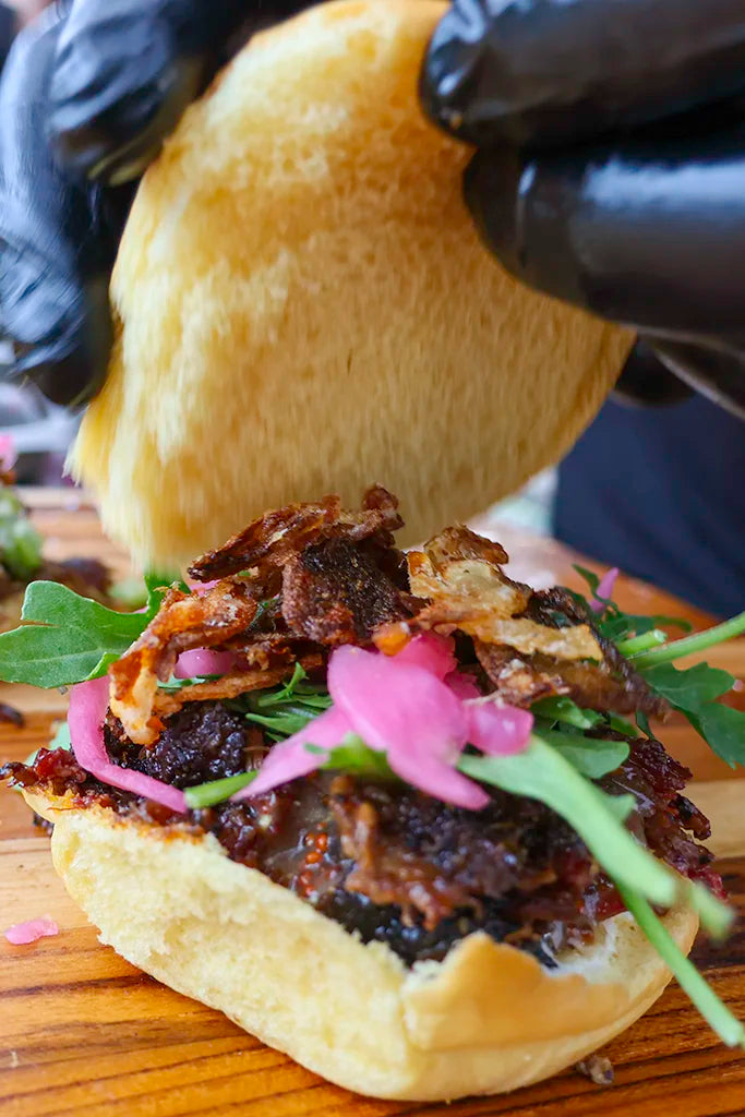 Pendragon's beef cheek sandwich with pickles, arugula, crispy onions and a roll
