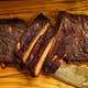 Sliced rack of Pen’s House ribs with two meaty bones placed on top, prepared for BBQ delivery in New Jersey
