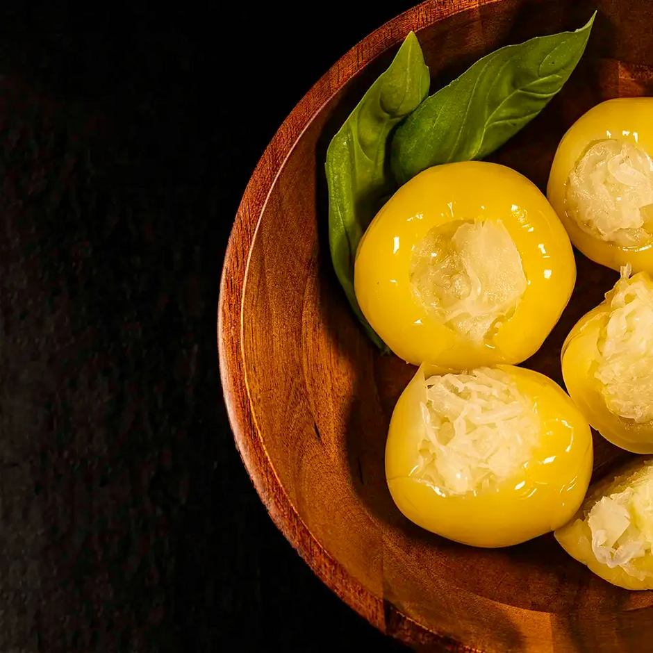 Hungarian alma pickles stuffed with cabbage. With basil leaves on a wooden plate against a dark background