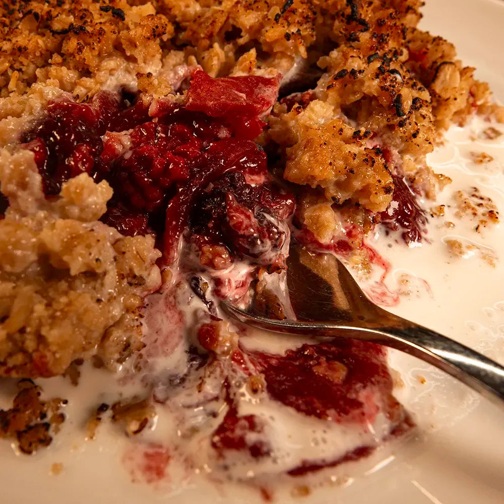 Charlie’s blackberry and apple crumble close-up with a fork digging into the golden oat topping