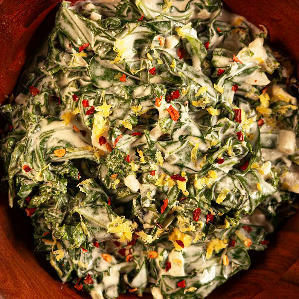 Creamed fall greens in a wooden bowl with kale and collards in a rich cream sauce