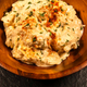 Creamy potato salad in a wooden bowl on a dark background