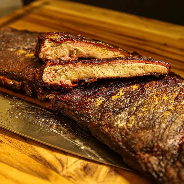 Sliced rack of Dragon’s Breath #3 ribs with two spice-rubbed bones stacked on top, ready for delivery