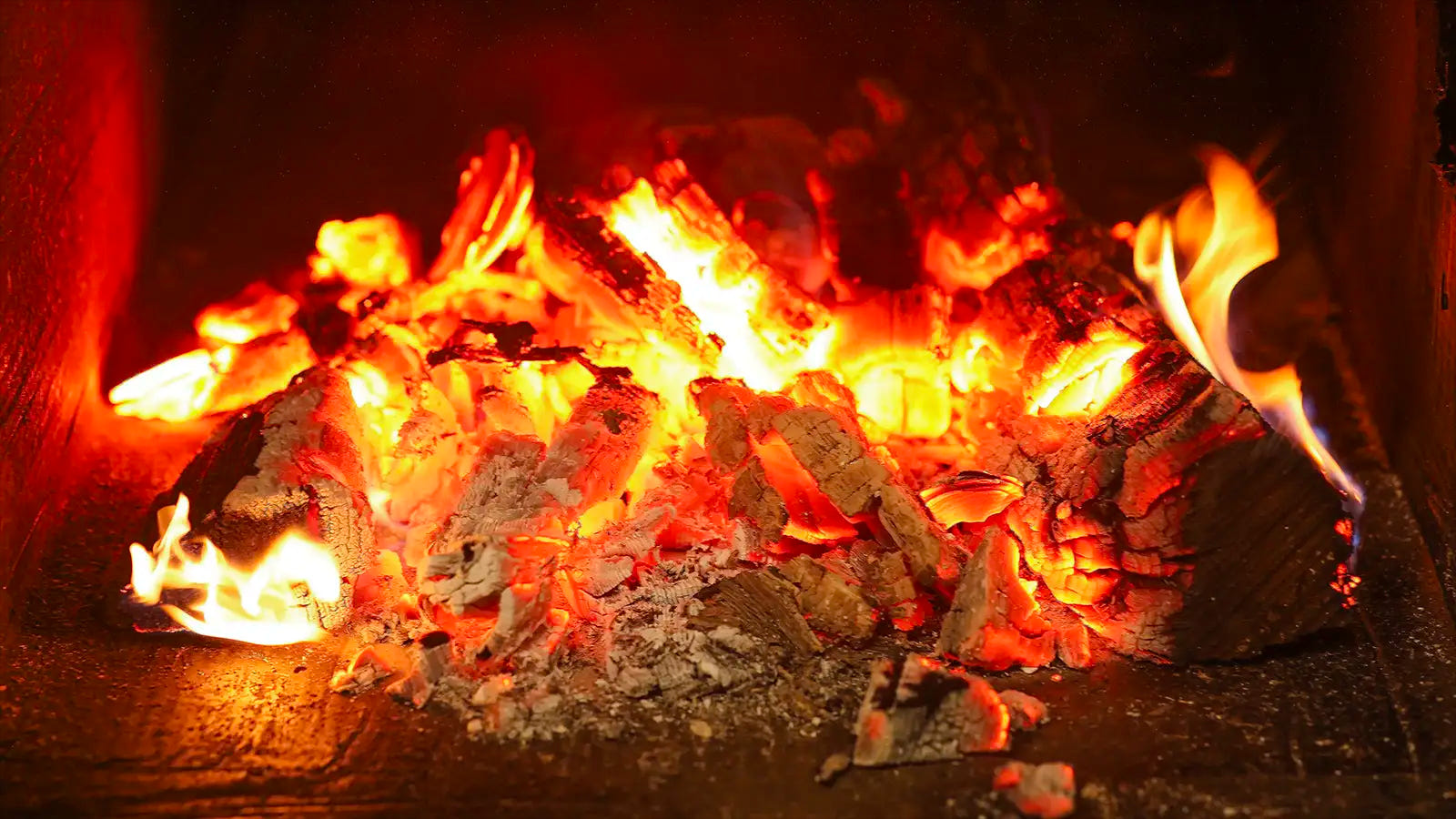 Glowing red coals inside the smoker firebox at Pendragon’s Smokehouse BBQ delivery kitchen in New Jersey