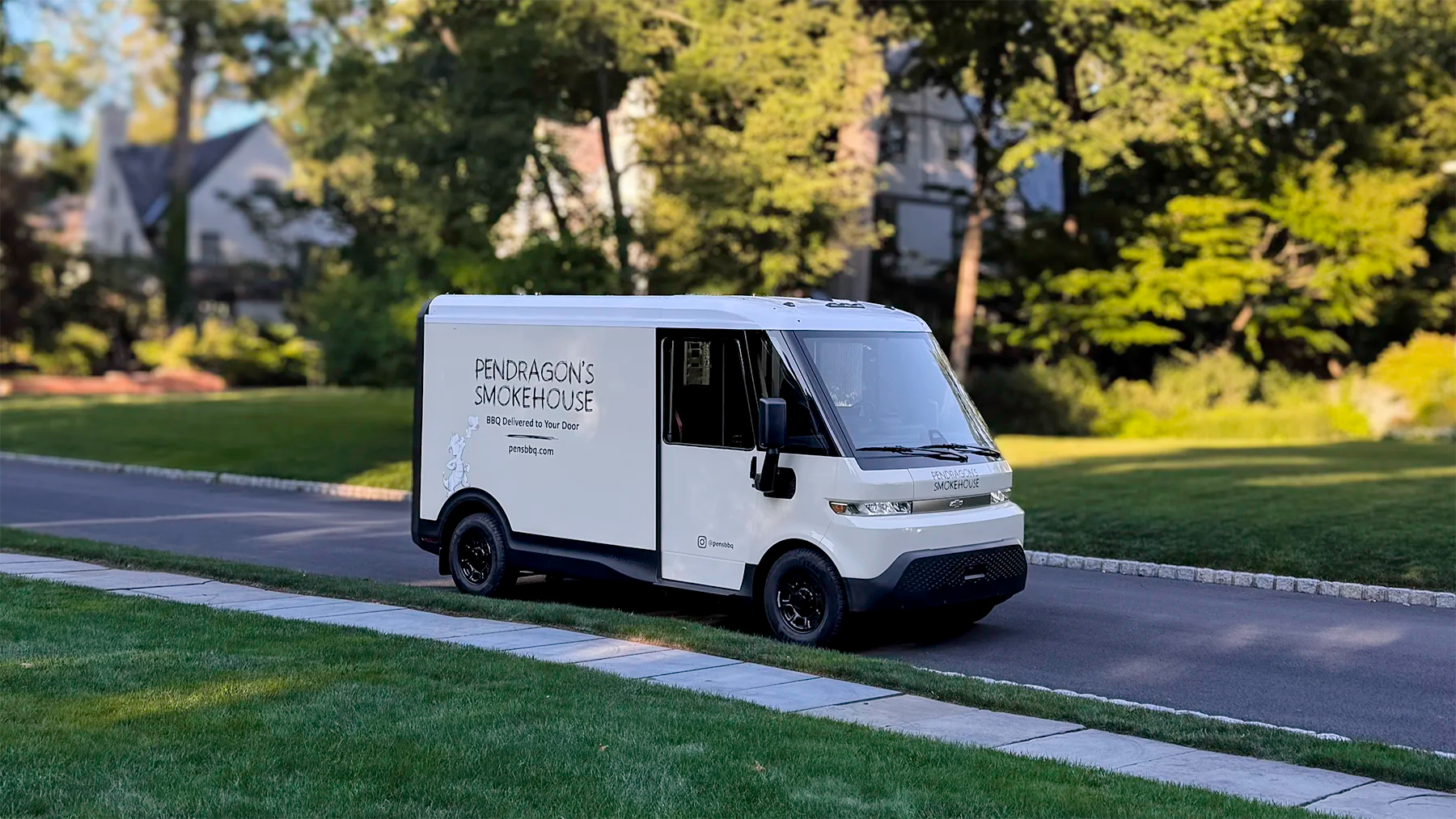 Electric delivery van on a residential street in Glen Ridge NJ with 'Pendragon's Smokehouse' branding.