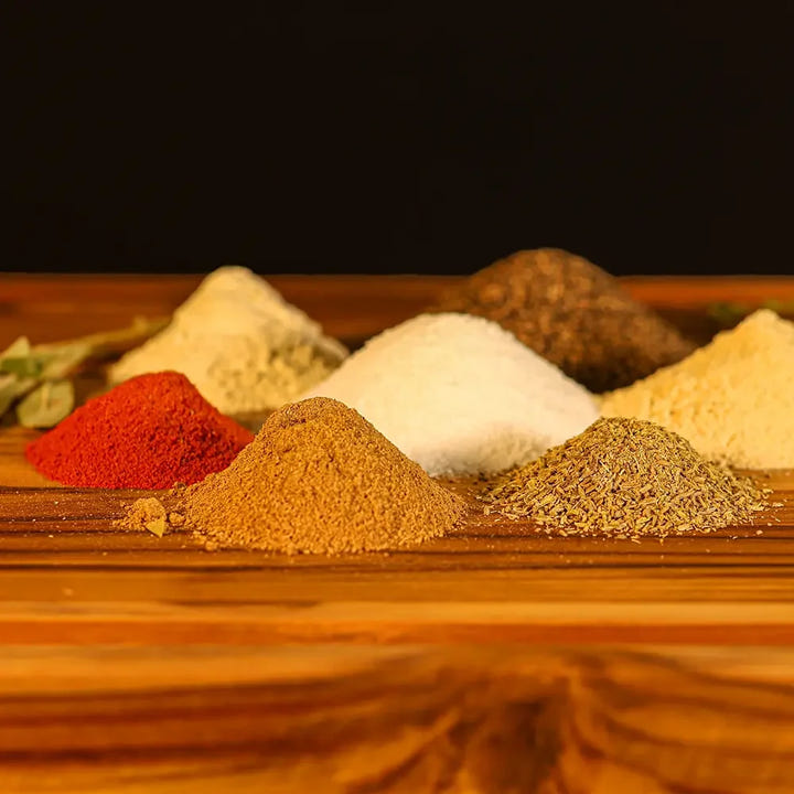 Mounds of coarse spices for Smokehouse Select rib rub, featuring paprika, garlic, and pepper ready for blending at Pendragon’s Smokehouse